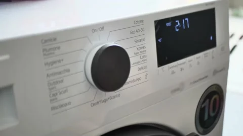 Man turns on the washing machine on the button close up Video stock 150079661