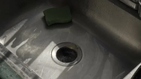 A man turns off the water and discards the sink garbage, his hands in close-up Video stock 232503583