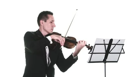 Man in a tuxedo performs a slow composition on a classical violin. Isolated Stock Footage 134495590