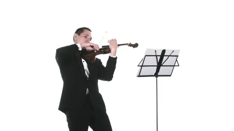 Man in a tuxedo performs a slow composition on a classical violin. Isolated Stock Footage 134495608