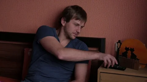 Man with tv remote changing channels and watching tv on comfortable sofa Stock Footage