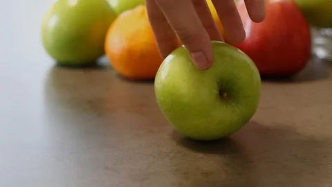 A man twists an apple with his hand. Movement and stop of fruit. Fresh vitamins. Stock Footage 112939523
