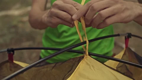 Man tying knots during the installation of the tent Stock Footage 165343073