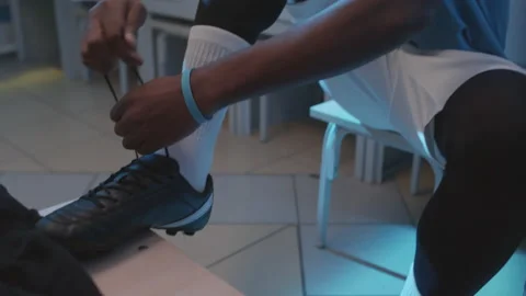 Man Tying up Laces on Cleats Видео 171312057