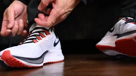 A man tying the right shoelace of his new Nike Zoom Air Pegasus right shoes Stock Footage