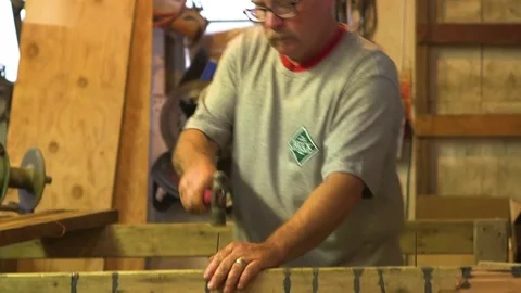 Man tying rope over two nails in the workshop Stock Footage 83179306