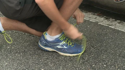 Man tying shoe before race Stock Footage 44754520