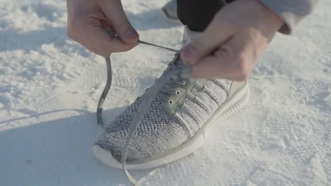 Man tying sneakers in winter Stock Footage 102281395