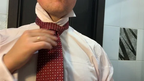 The man is tying a tie. Video stock 95849173
