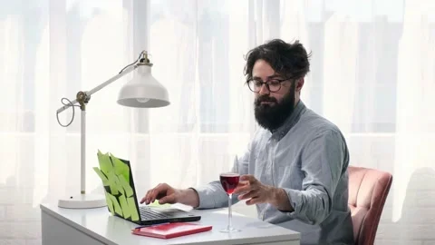 Man types and then drink a glass of wine and looks happily at the screen. Stock Footage 152837001
