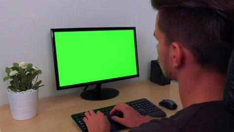 A man types on a computer with a green screen 스톡 동영상 71175156