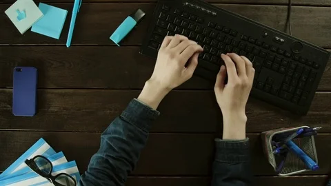 A man types on a computer keyboard on his desk. Stock Footage 82001129