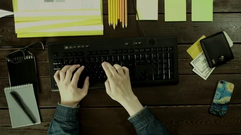 A man types on a computer keyboard on his desk and thinks. Stock Footage 82008969