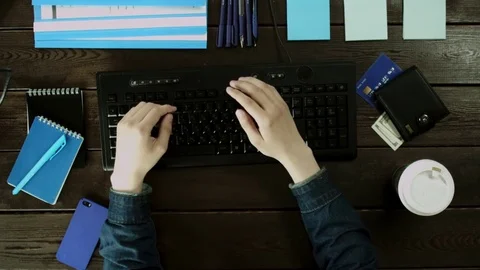 A man types on a computer keyboard on his desk and hiding something that prints Stock Footage 82012540