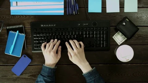 A man types on a computer keyboard on his desk. Stock Footage 82013574