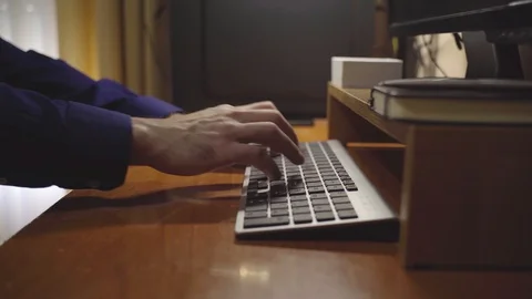 Man types on his computer keyboard while working. Concept of work at home or Stock Footage 129909484