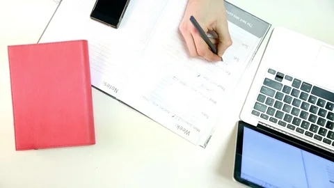 Man types on laptop and writes down notes Stock Footage 72312141