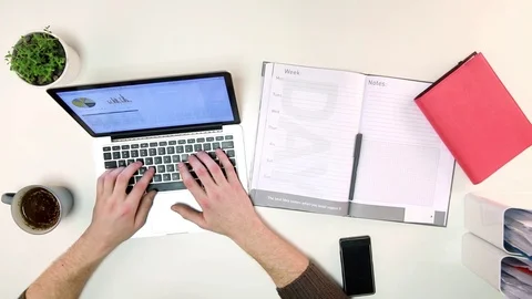 Man types on laptop and writes down notes Stock Footage 72312165