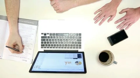 Man types on laptop and writes down notes Stock Footage 72312168