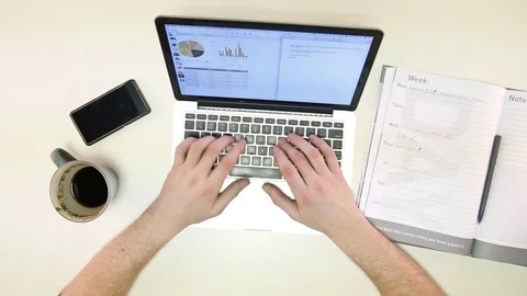Man types on laptop and writes down notes Stock Footage 72312175