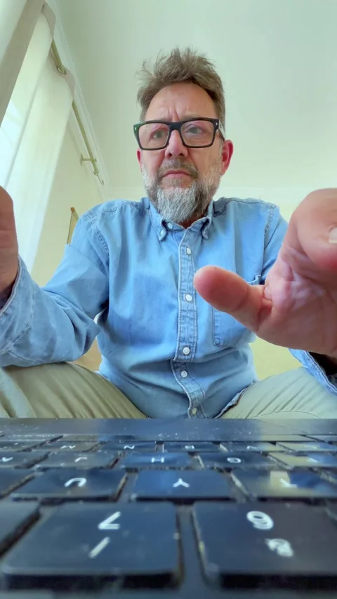 Man types on a laptop, pausing to think deeply, suggesting problem-solving or cr Stock Footage 335241139