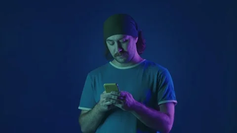 A man types a message on a smartphone, looks through his feed on social networks Stock Footage 252016757