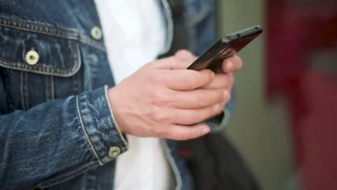 A man types on a mobile phone. Young man's hands texting on phone Stock Footage 156189575
