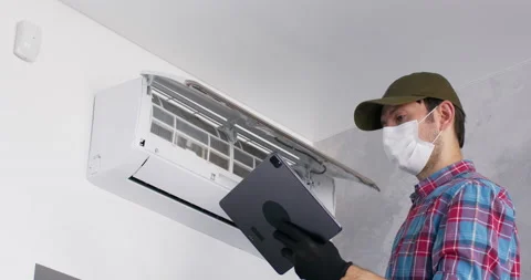Man types report on tablet about repaired conditioner Stockbeeldmateriaal 205504001