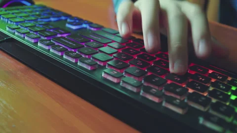 A man types text on a backlit keyboard. Stock Footage 154772091