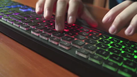 A man types text on a backlit keyboard. Stock Footage 154933067