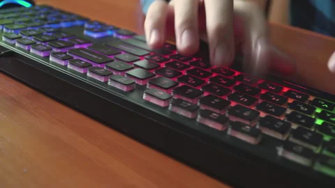 A man types text on a backlit keyboard. Stock Footage 154933244