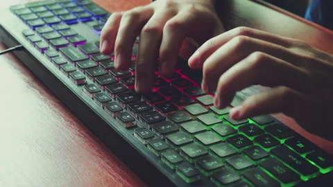 A man types text on a backlit keyboard. Stock Footage 154933721
