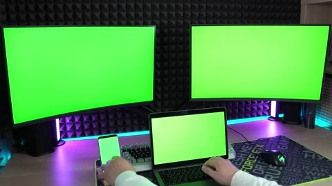A man types text on a laptop and scrolls through the feed on his smartphone Stock Footage 249890753