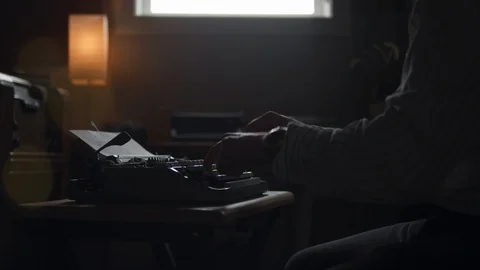 Man types on a typewriter, pulls the paper out to check his work and walks out Video stock 97858964