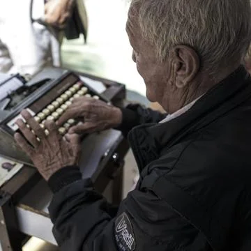 Man on typewriter during the day Photos