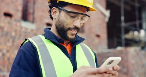 Man, typing and phone on construction site with schedule, building app and happy Stock Footage 336778940