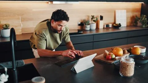 Man, typing and tablet in kitchen with breakfast, healthy food or search bl.. Stock Photos