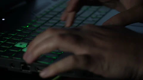 A man typing on a backlit keyboard that flashes in different colors Vidéo 237374880
