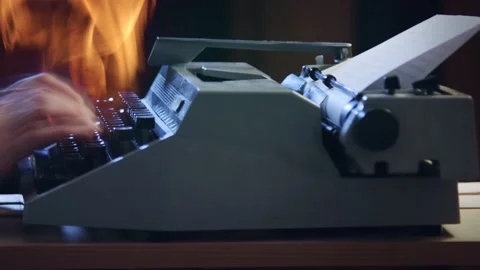 A man typing on a burning typewriter Stockbeeldmateriaal 175720527