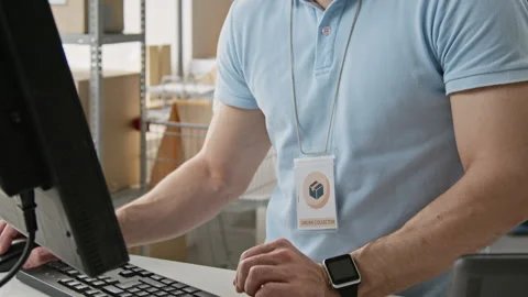 Man Typing on Computer in E-commerce Order Fulfillment Center Stock Footage 346057508