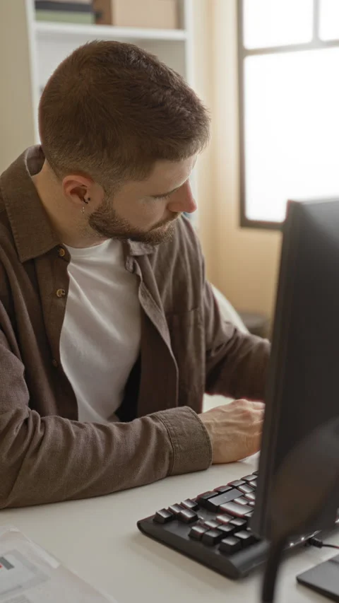 Man typing on a computer, hands on keyboard in a studio with bookshelf and .. Stock Footage 337365406
