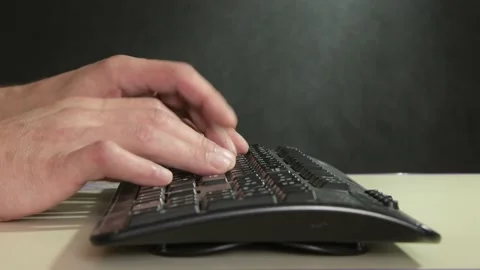 A man is typing on a computer keyboard on a dark background, a close-up of his h Video stock 219326075