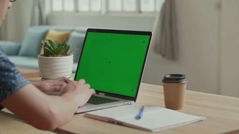 Man Typing On Computer Keyboard Of A Laptop Computer With Green Screen Display Stock Footage 153104058