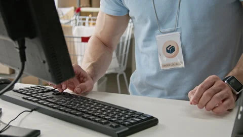 Man Typing on Computer Keyboard in Warehouse Fulfillment Center Stock Footage 346067903