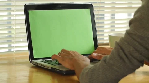 Man typing on computer laptop keyboard with green screen Stock Footage 56930805