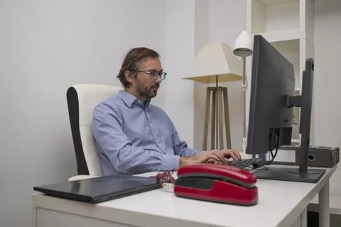 Man typing on computer in modern office Stockfoto's