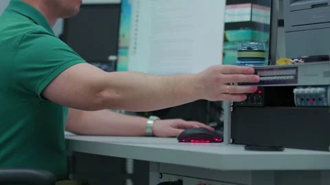 A man is typing on a computer with a red lights mouse nearby Stock Footage 276969863