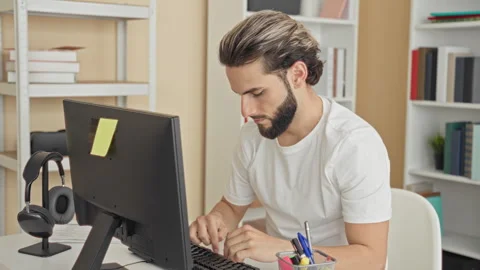 Man typing on desktop computer with fingers on keyboard, headphones on stan.. Stock Footage 337371943