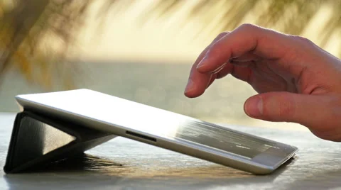 Man typing on a digital tablet on the beach Stock Footage 50240274
