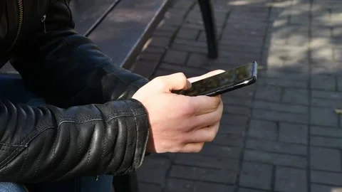 A man is typing on his smartphone, scrolling through social networks, dialing a  스톡 동영상 211426542